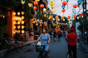 Vietnamese-woman-biking-street-lanterns-hung-above-Hoi-An-Vietnam